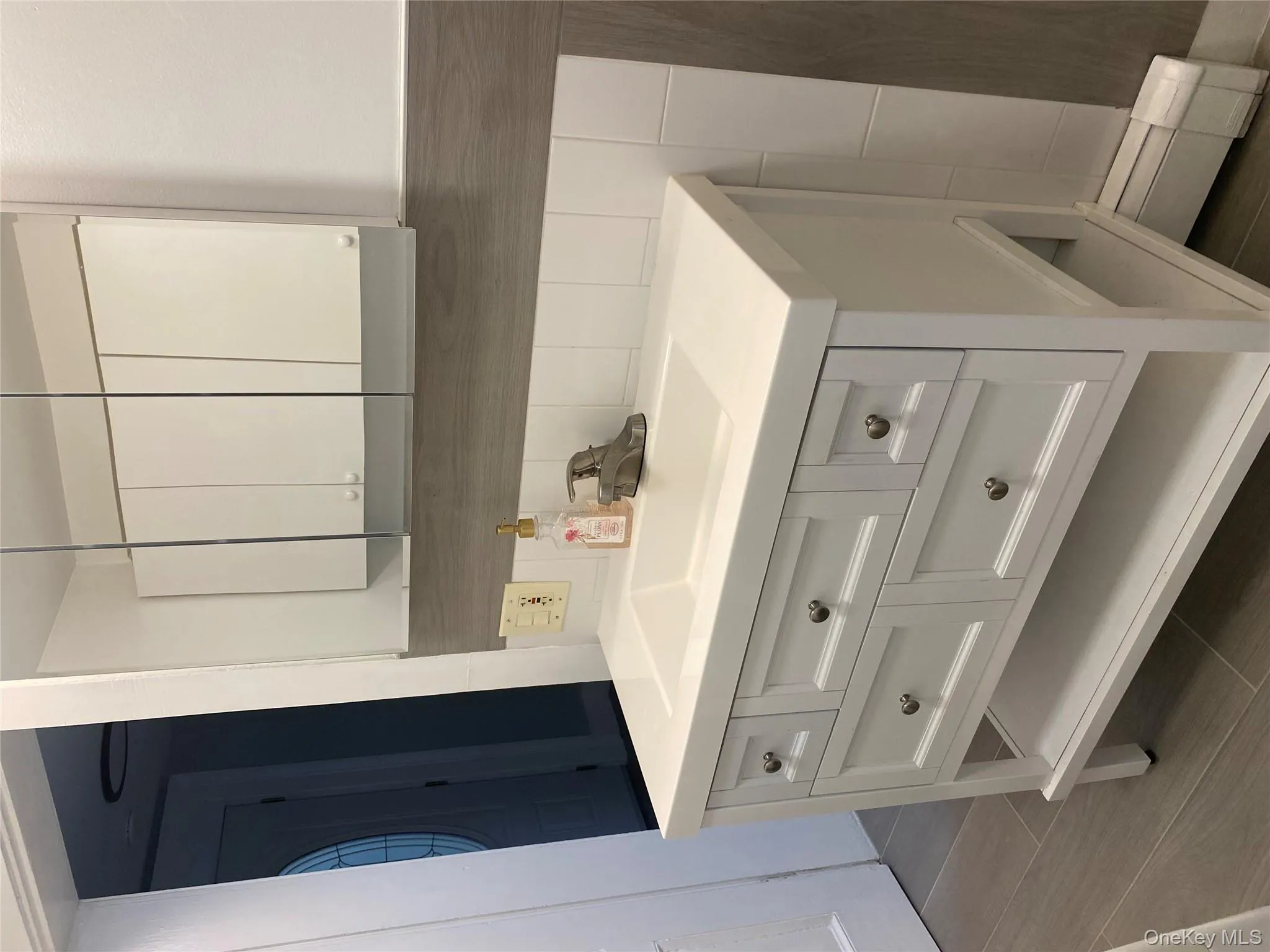 Bathroom with vanity, baseboard heating, and dark wood-style flooring Bathroom with vanity, baseboard heating, and dark wood-style flooring