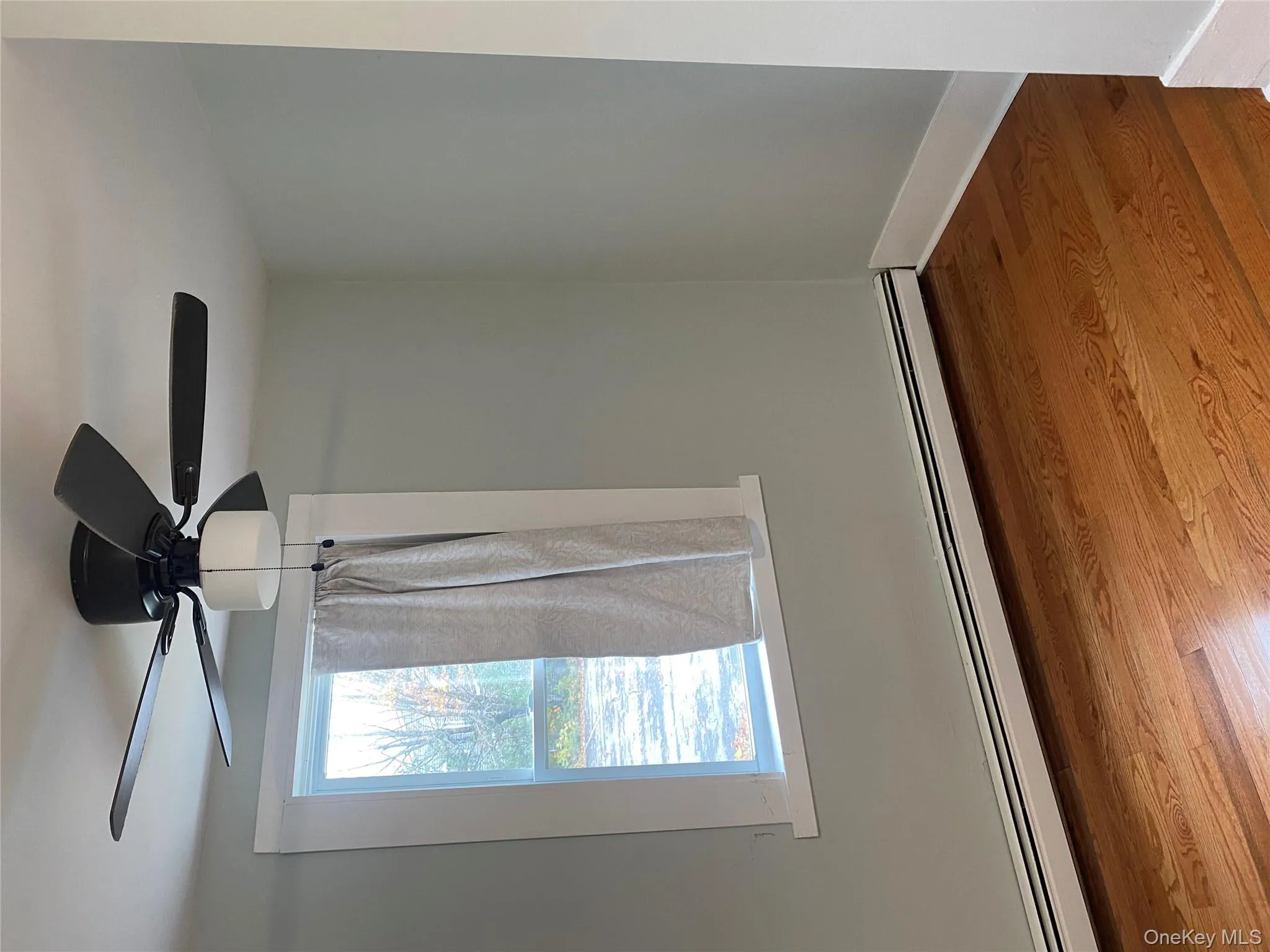 Spare room featuring a baseboard heating unit, wood finished floors, and ceiling fan Spare room featuring a baseboard heating unit, wood finished floors, and ceiling fan