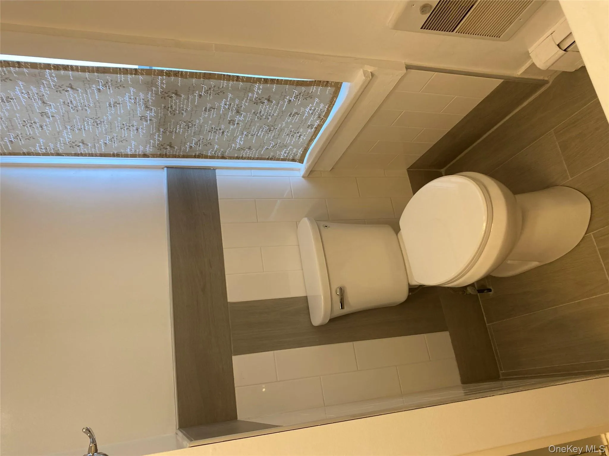 Half bath with tile walls, a wainscoted wall, and baseboard heating Half bath with tile walls, a wainscoted wall, and baseboard heating