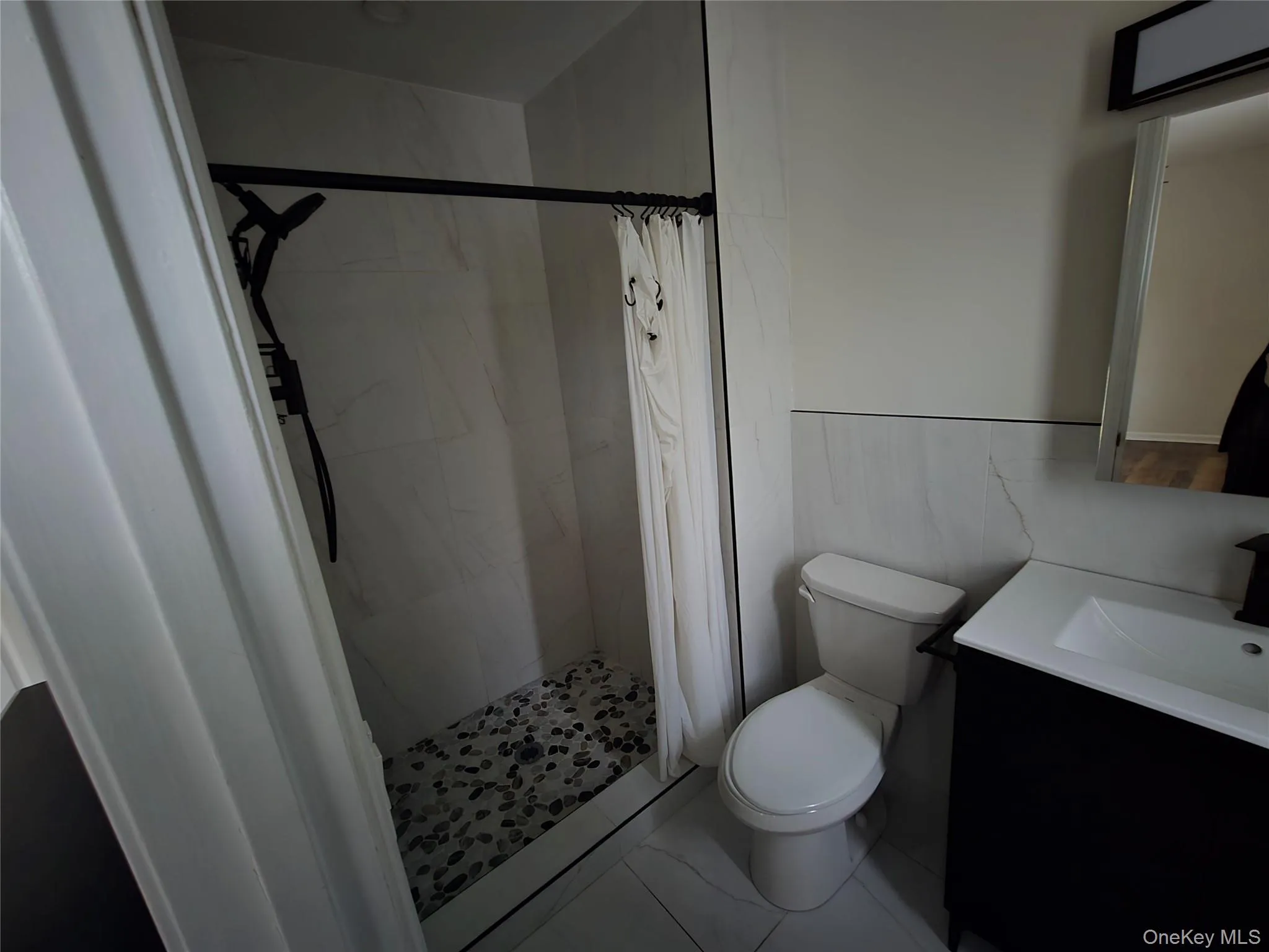 Bathroom with a marble finish shower and vanity Bathroom with a marble finish shower and vanity