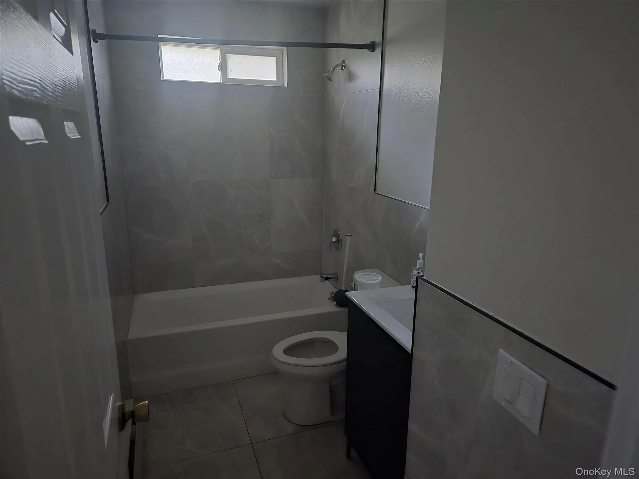 Bathroom with vanity, shower / bathtub combination, and light tile patterned floors Bathroom with vanity, shower / bathtub combination, and light tile patterned floors