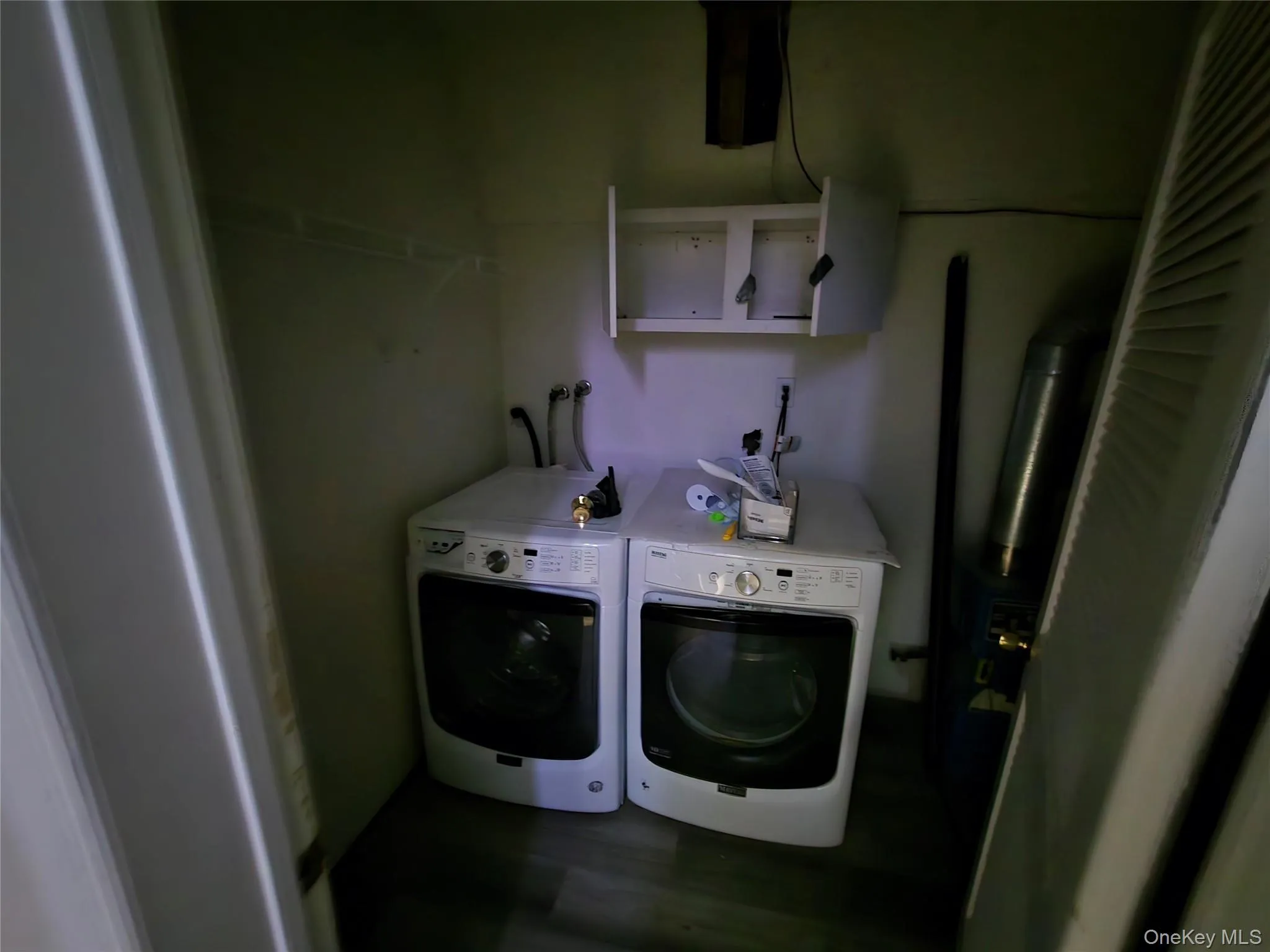 Laundry room with dark wood-style floors and washing machine and clothes dryer Laundry room with dark wood-style floors and washing machine and clothes dryer