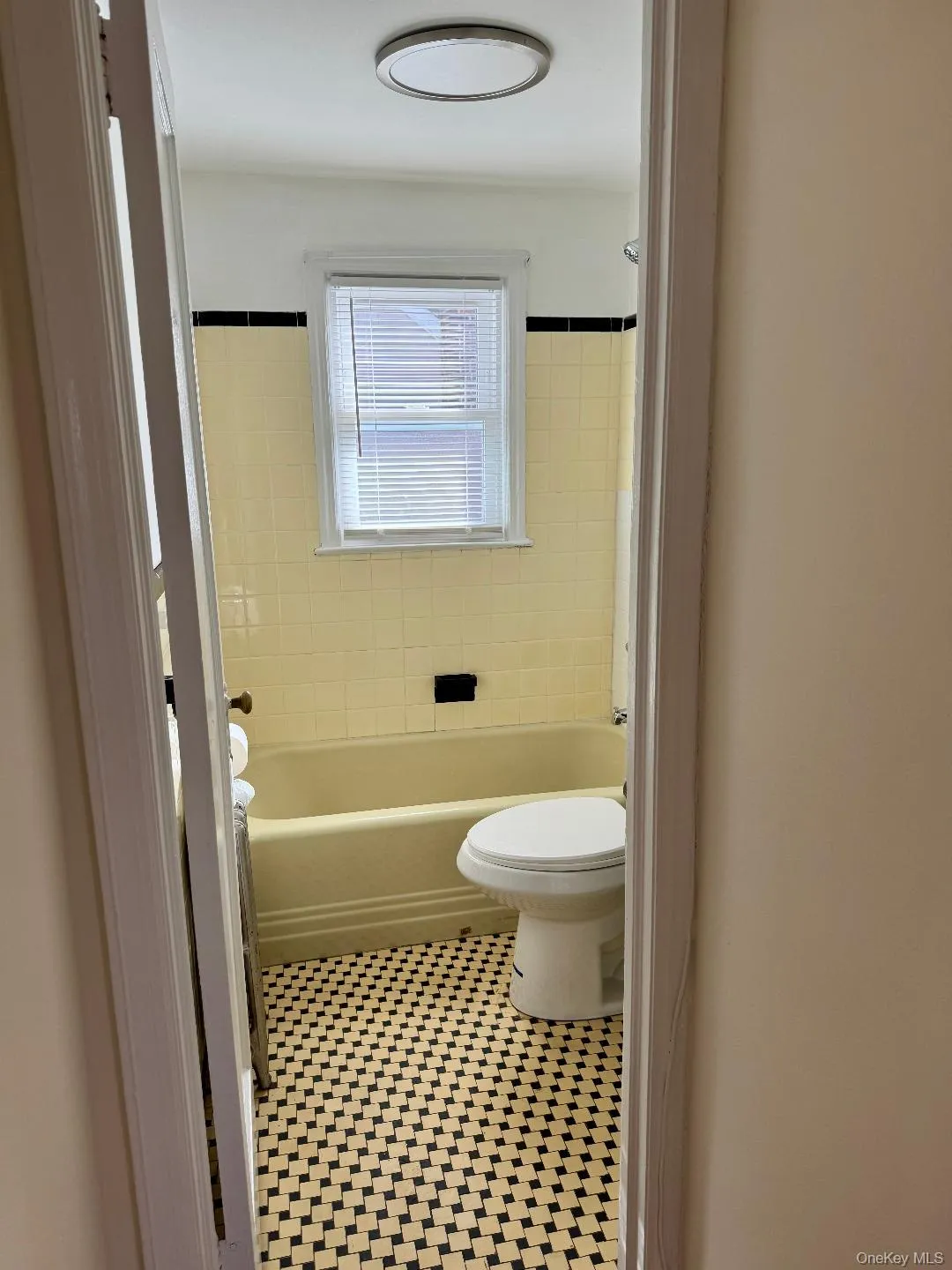 Bathroom featuring tile patterned flooring and bathtub / shower combination Bathroom featuring tile patterned flooring and bathtub / shower combination