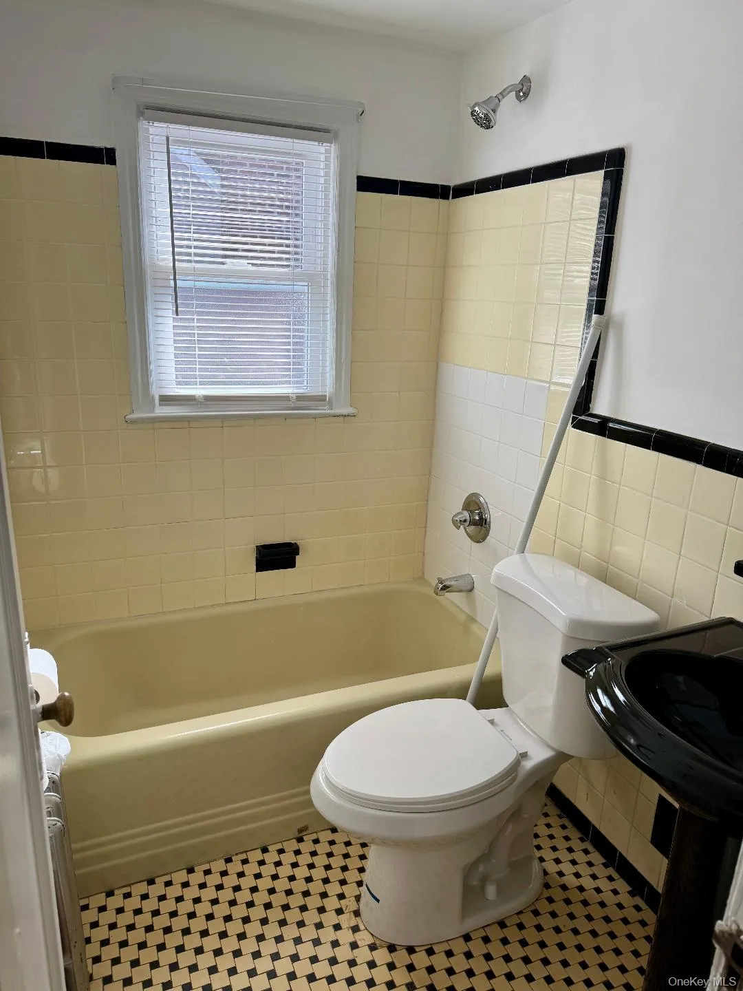 Bathroom featuring tile walls, shower / bath combination, and light tile patterned floors Bathroom featuring tile walls, shower / bath combination, and light tile patterned floors