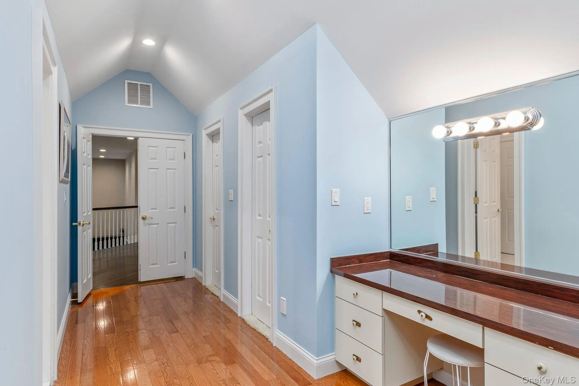 vaulted ceiling, light wood-style flooring, vanity, and recessed lighting vaulted ceiling, light wood-style flooring, vanity, and recessed lighting