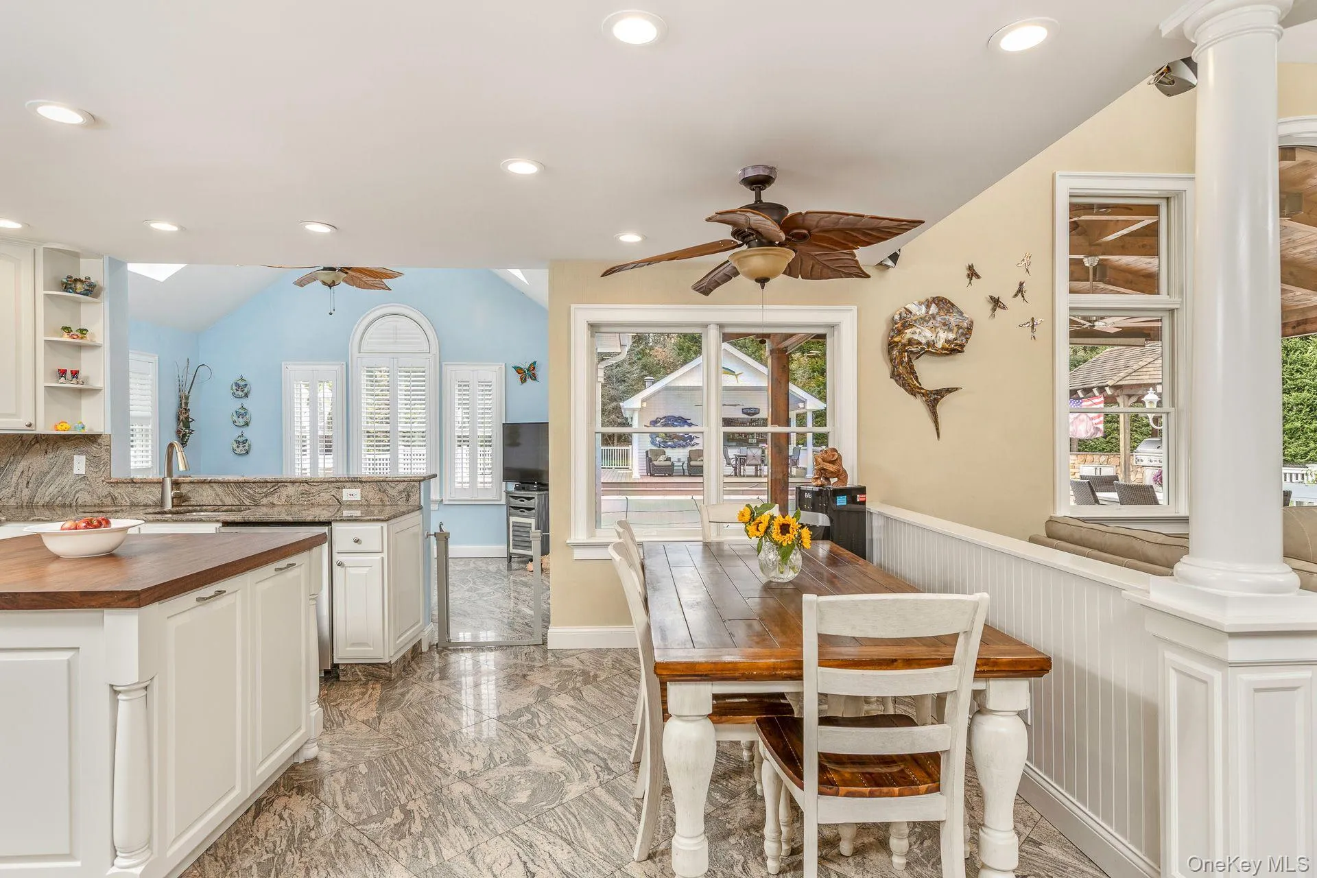 Dining area featuring light marble finish floors, recessed lighting, vaulted ceiling, decorative columns, and ceiling fan Dining area featuring light marble finish floors, recessed lighting, vaulted ceiling, decorative columns, and ceiling fan