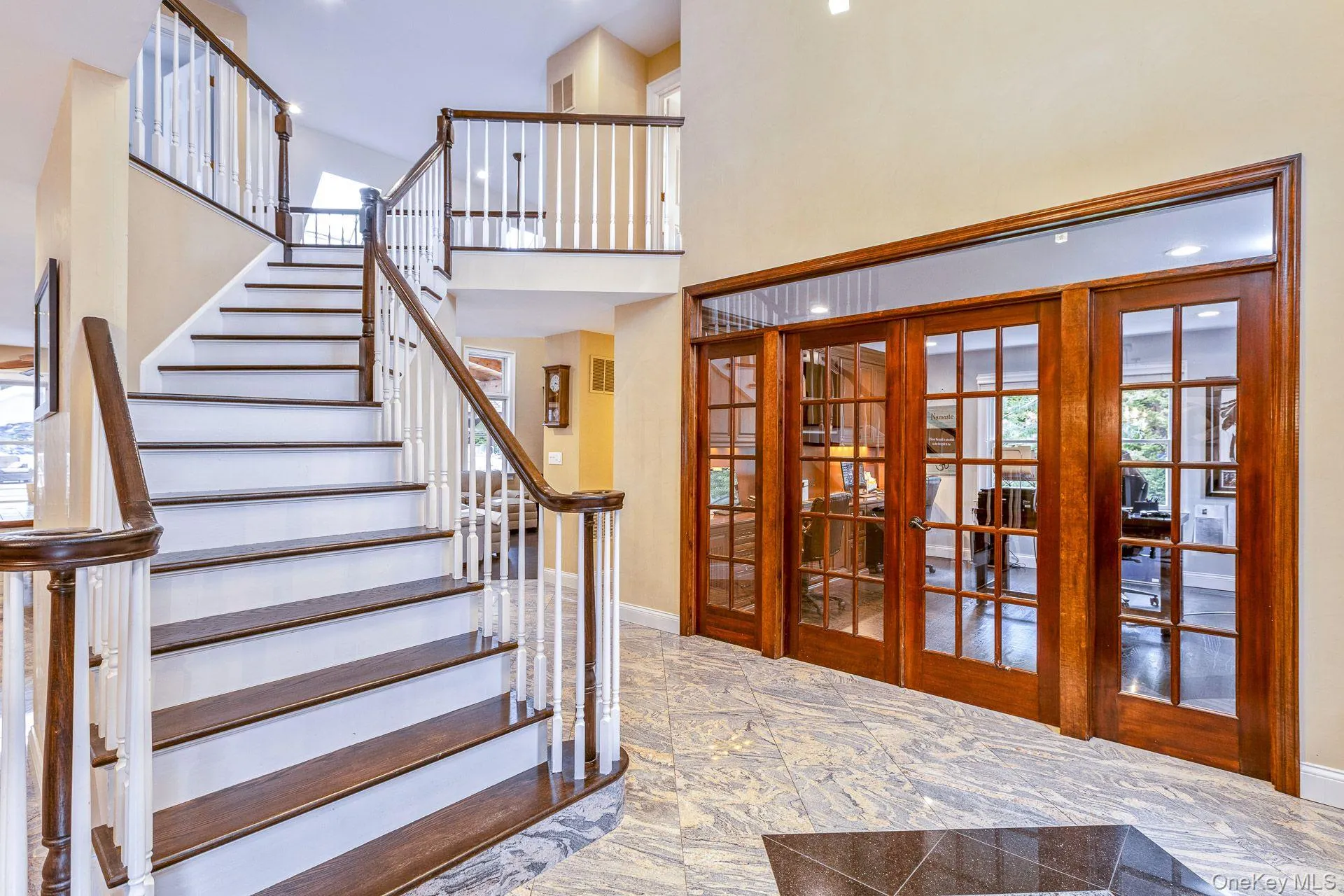 Staircase featuring french doors of office, a towering ceiling, and recessed lighting Staircase featuring french doors of office, a towering ceiling, and recessed lighting