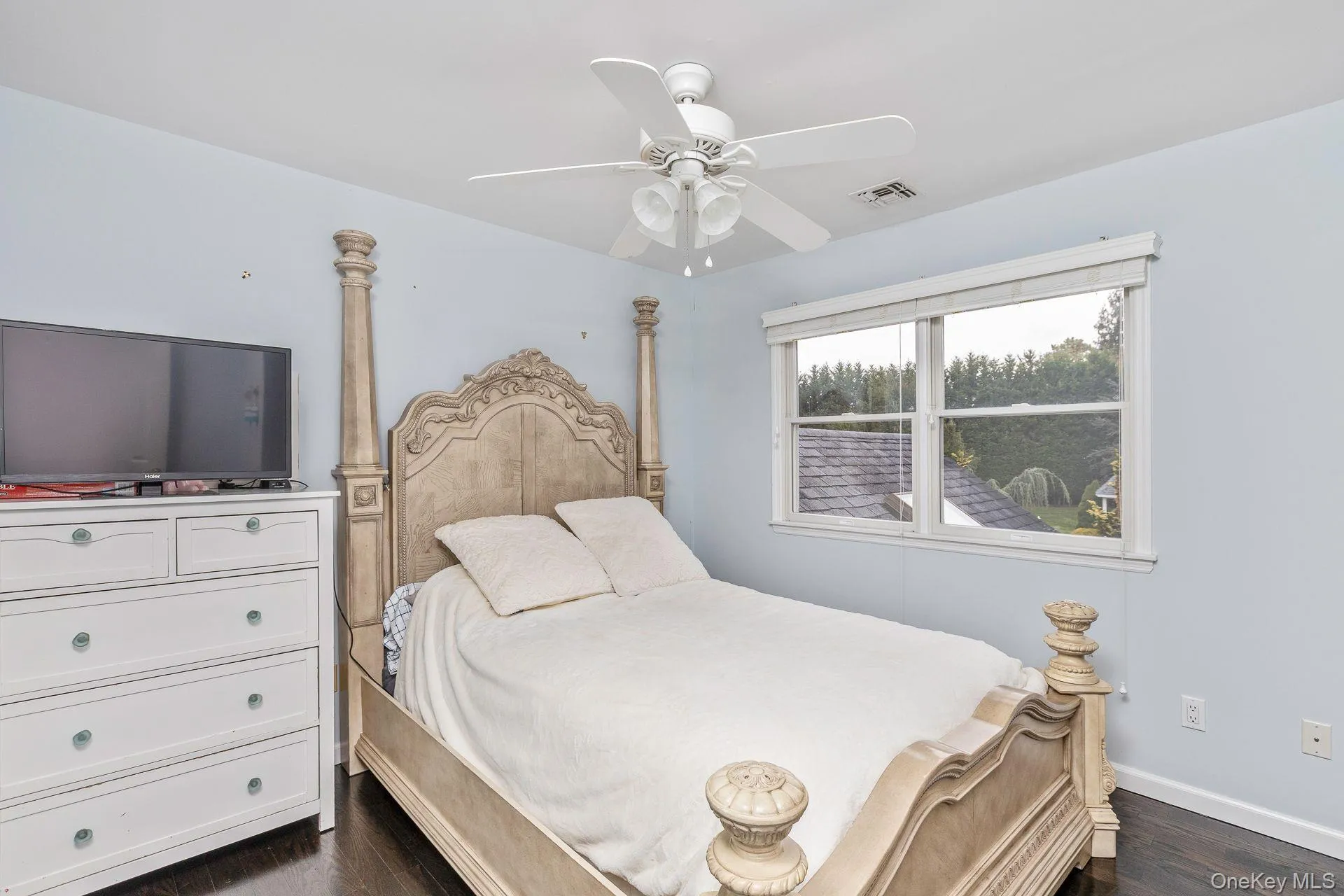 Bedroom with dark wood-style floors and a ceiling fan Bedroom with dark wood-style floors and a ceiling fan