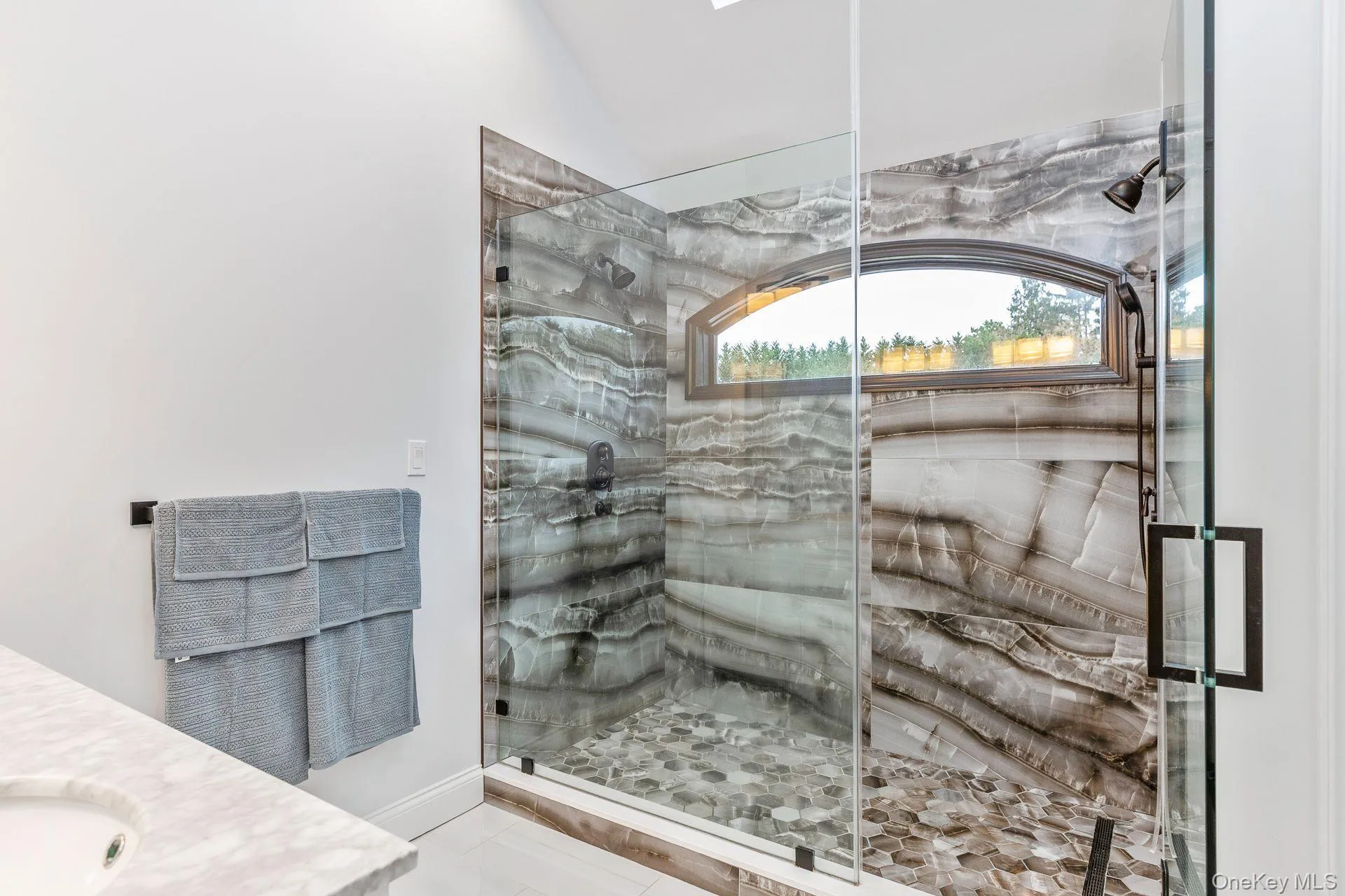 Full bath with vanity, a marble finish shower, and light tile patterned flooring Full bath with vanity, a marble finish shower, and light tile patterned flooring