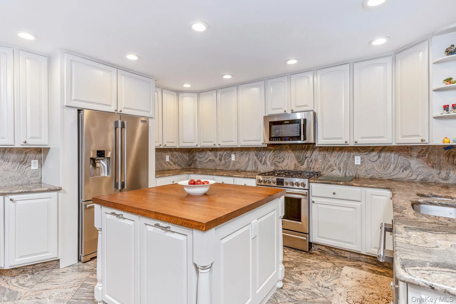 Kitchen with decorative backsplash, wood counters, white cabinets, stainless steel appliances, and recessed lighting Kitchen with decorative backsplash, wood counters, white cabinets, stainless steel appliances, and recessed lighting