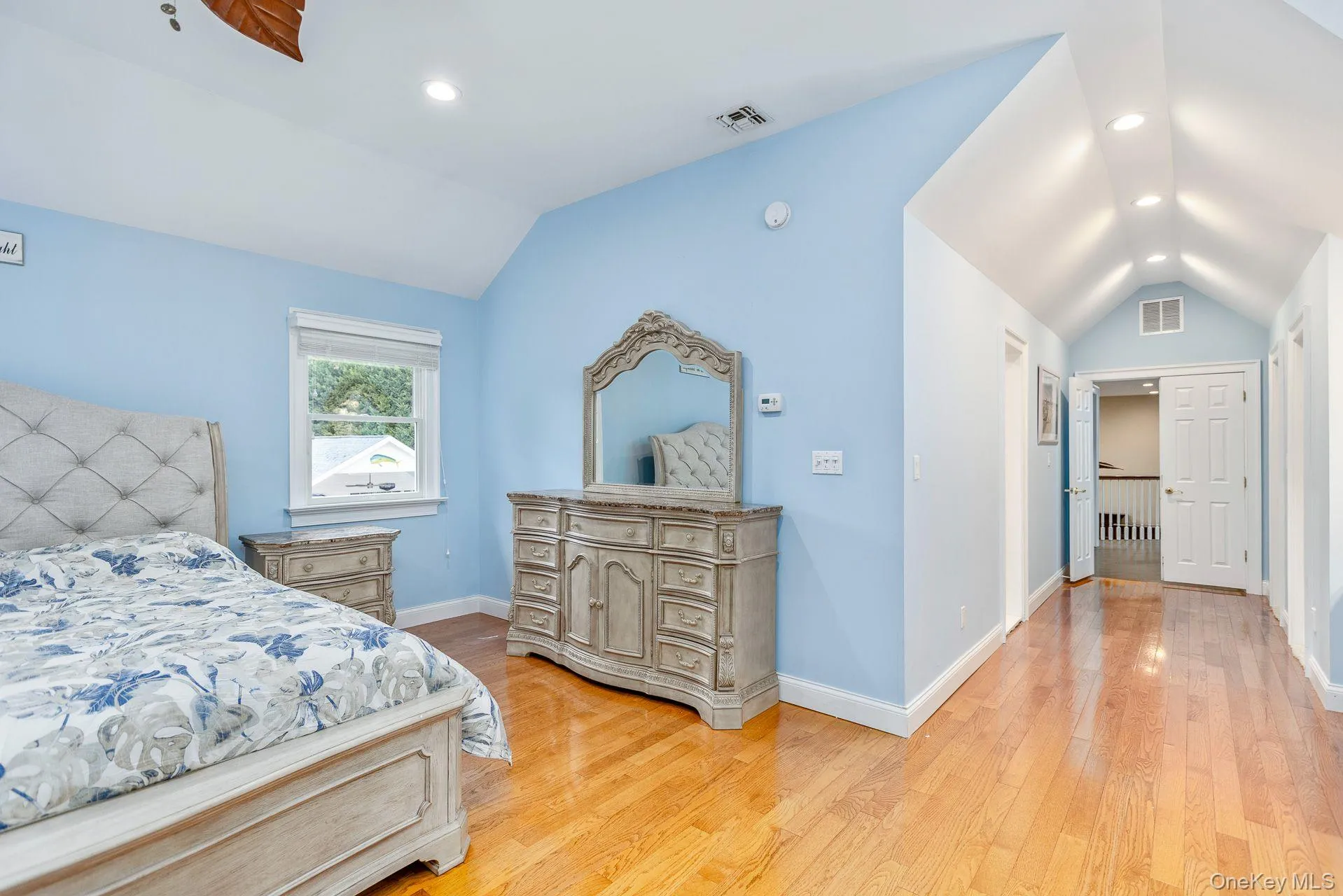Bedroom with lofted ceiling, light wood-style flooring, and recessed lighting Bedroom with lofted ceiling, light wood-style flooring, and recessed lighting