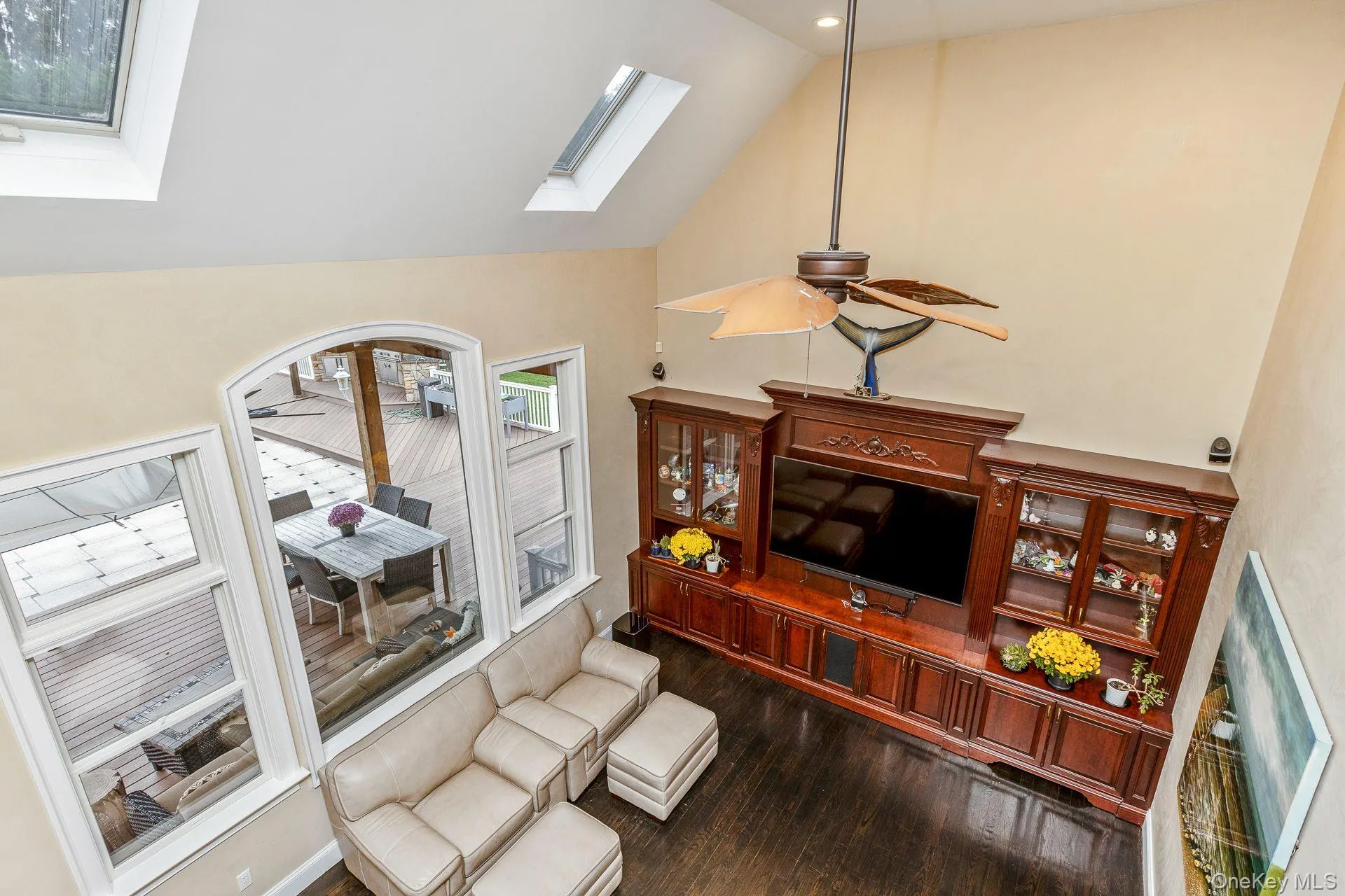 Living room with high vaulted ceiling, dark wood-style floors, and a skylight Living room with high vaulted ceiling, dark wood-style floors, and a skylight