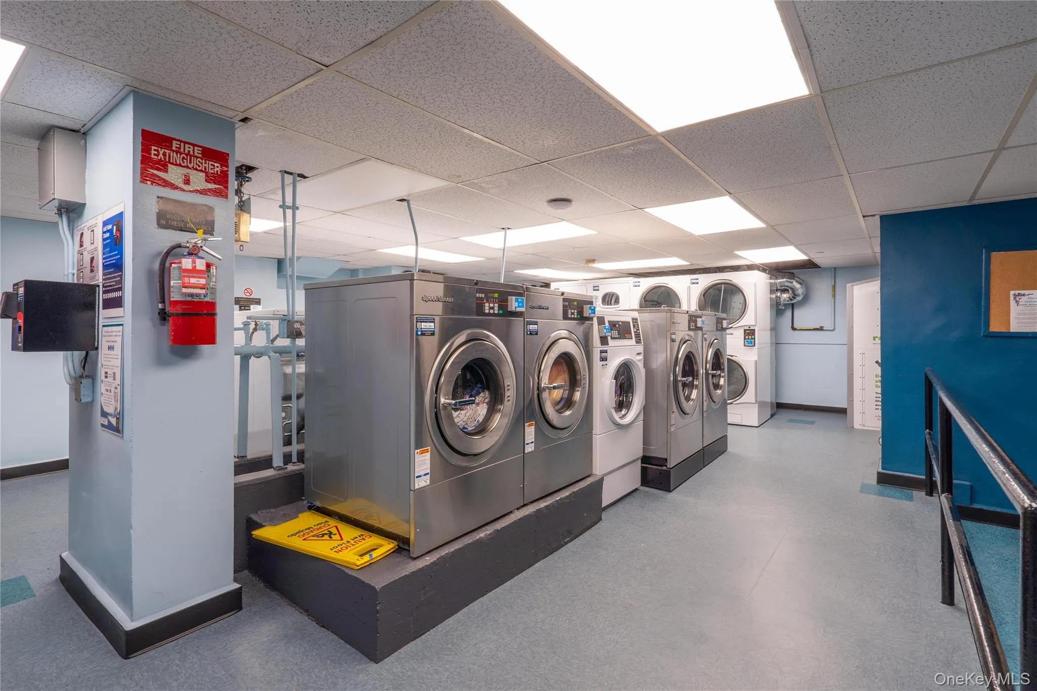 Shared laundry featuring a drop ceiling and washing machine and clothes dryer Shared laundry featuring a drop ceiling and washing machine and clothes dryer