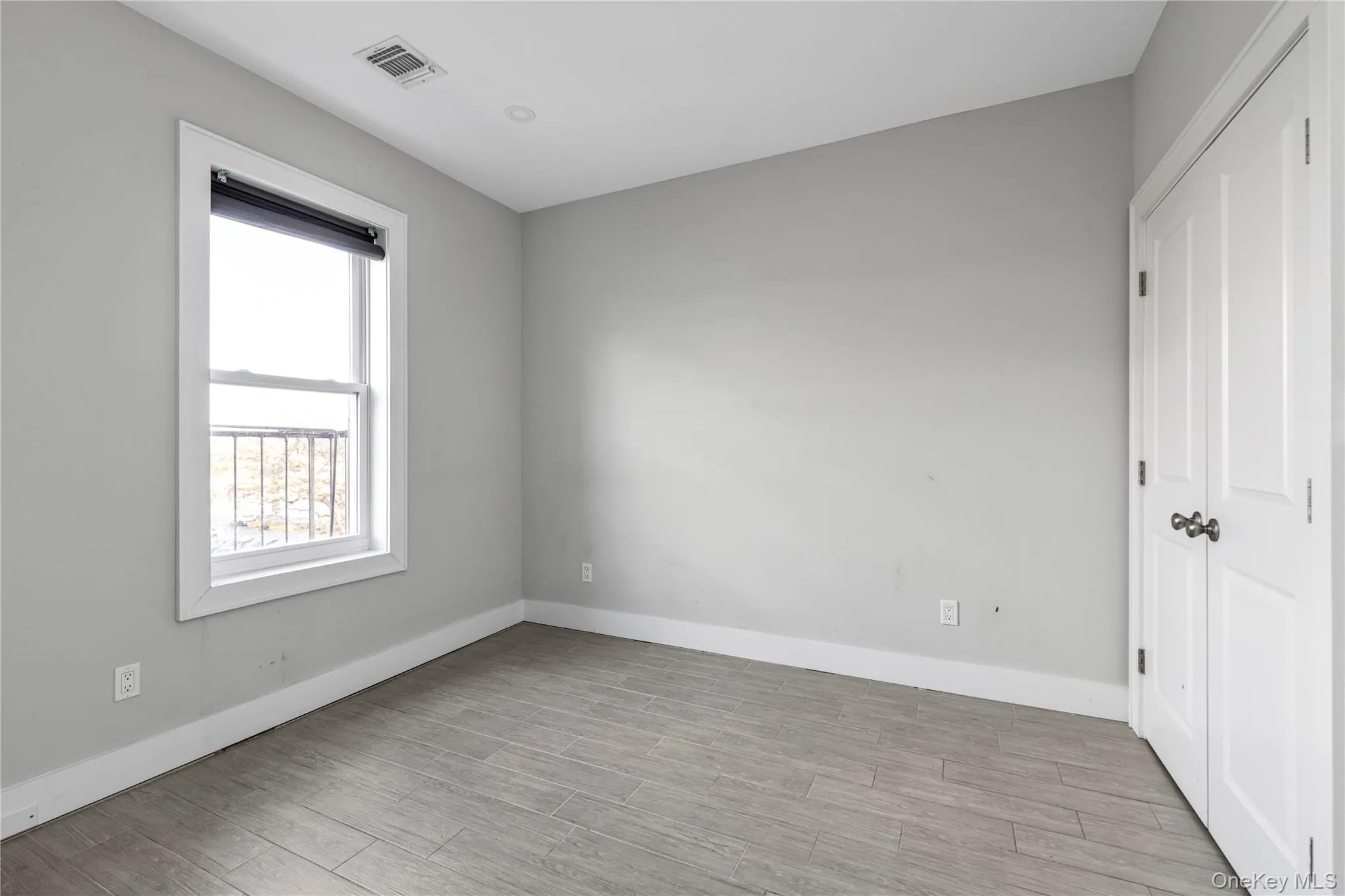 Empty room with baseboards and light wood finished floors Empty room with baseboards and light wood finished floors