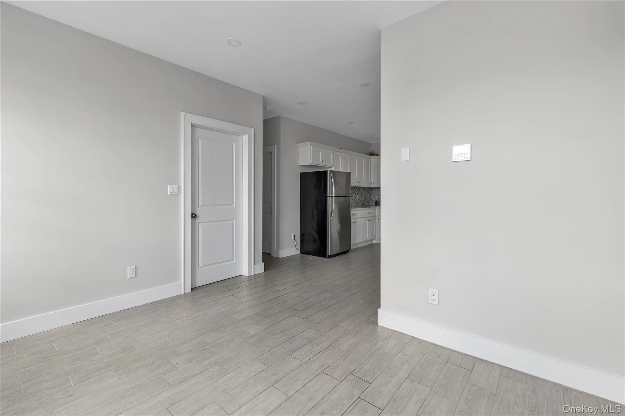 Unfurnished room with light wood-type flooring and baseboards Unfurnished room with light wood-type flooring and baseboards