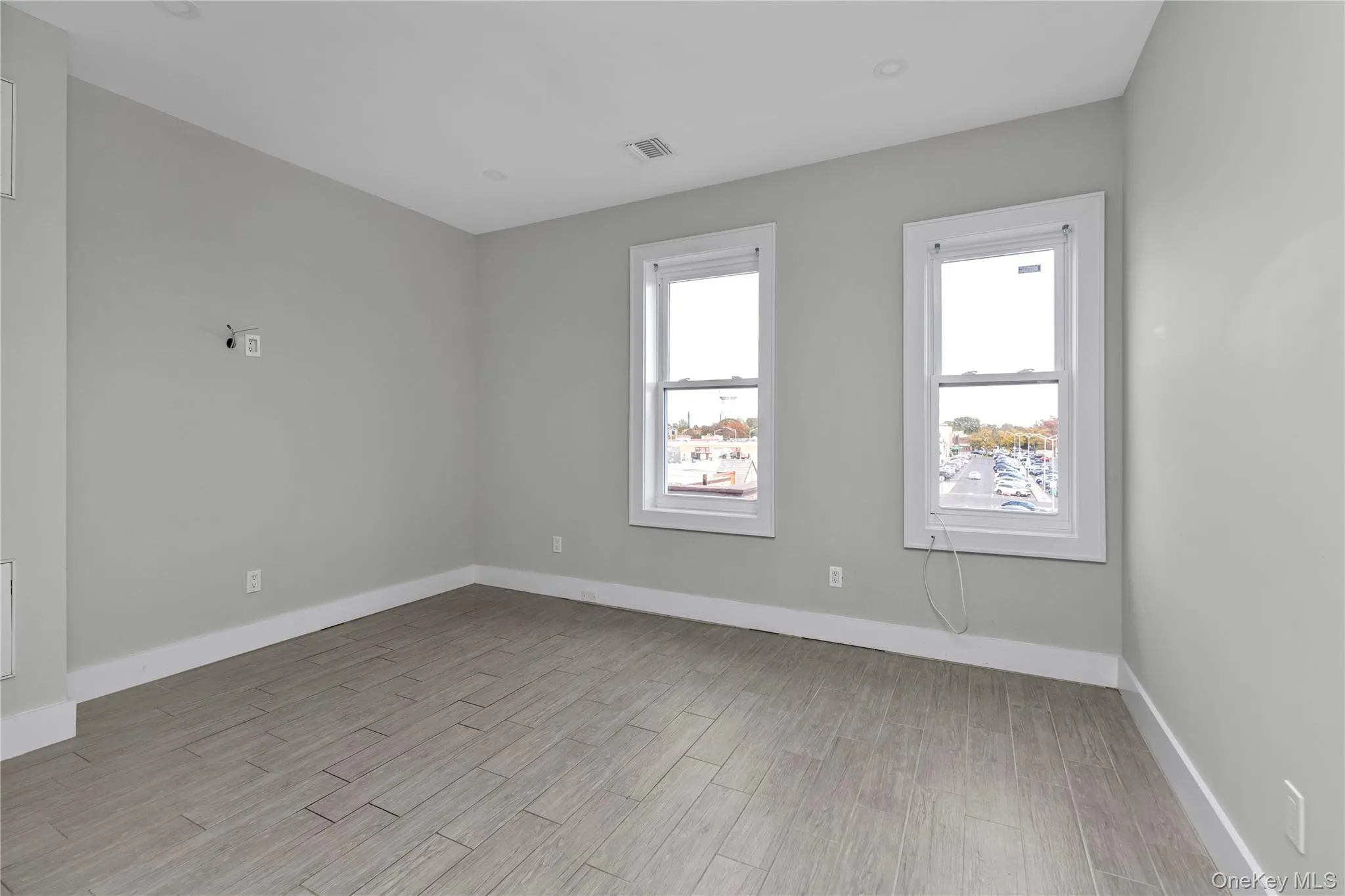 Spare room with baseboards and light wood finished floors Spare room with baseboards and light wood finished floors