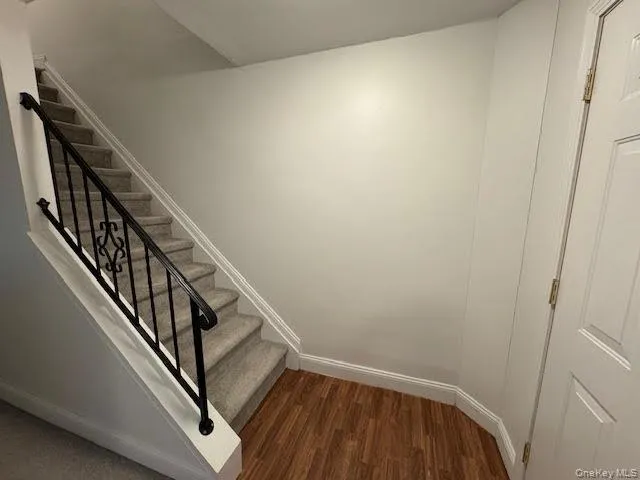 Stairway featuring baseboards and wood finished floors Stairway featuring baseboards and wood finished floors