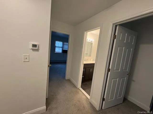 Corridor with dark colored carpet and baseboards Corridor with dark colored carpet and baseboards