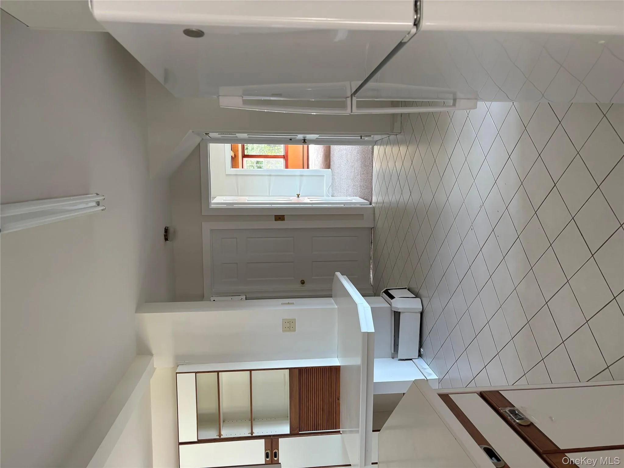 Kitchen featuring refrigerator, light tile patterned flooring, light countertops, and white cabinets Kitchen featuring refrigerator, light tile patterned flooring, light countertops, and white cabinets