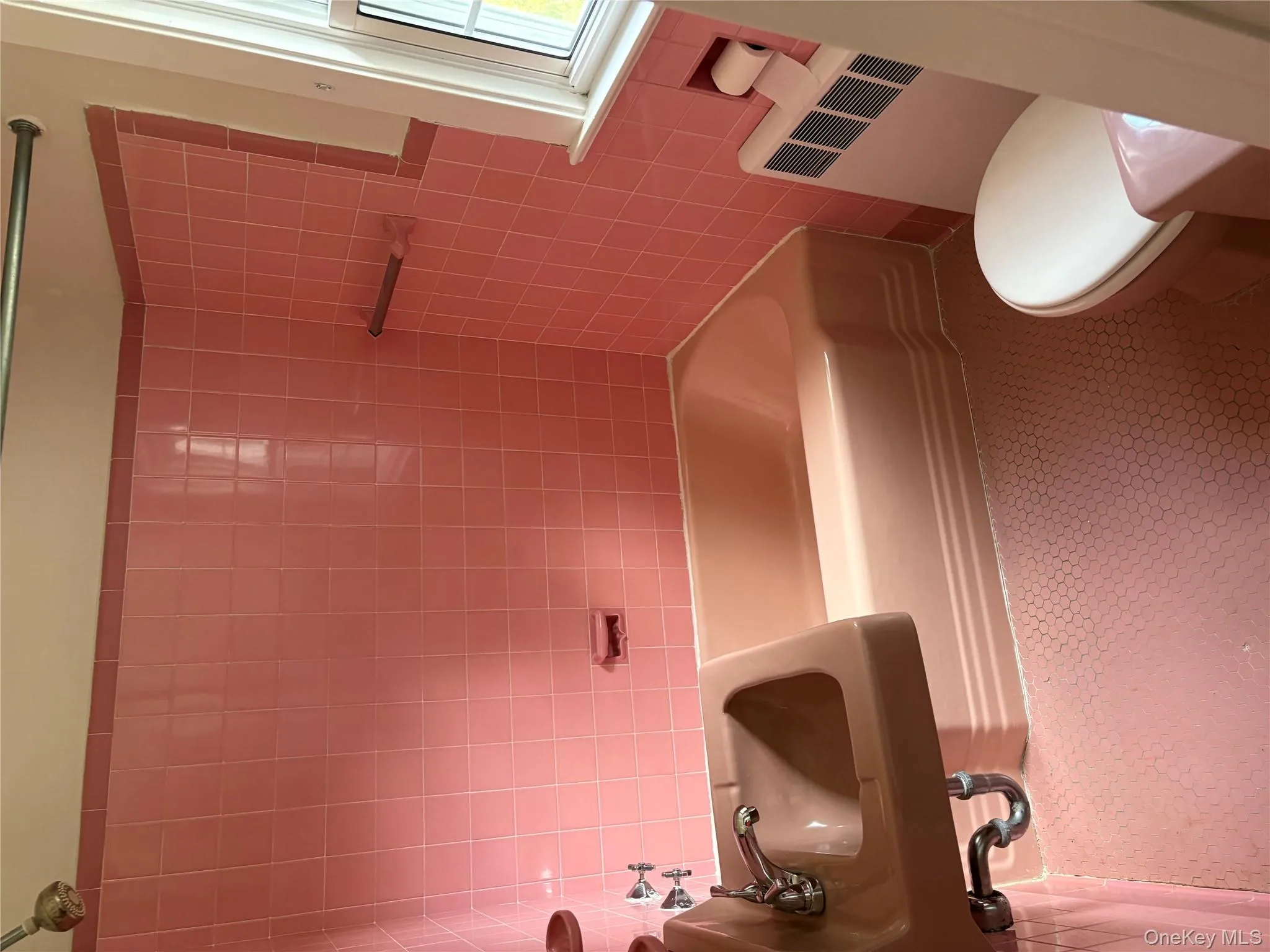 Bathroom with washtub / shower combination, radiator, tile walls, and tile patterned floors Bathroom with washtub / shower combination, radiator, tile walls, and tile patterned floors