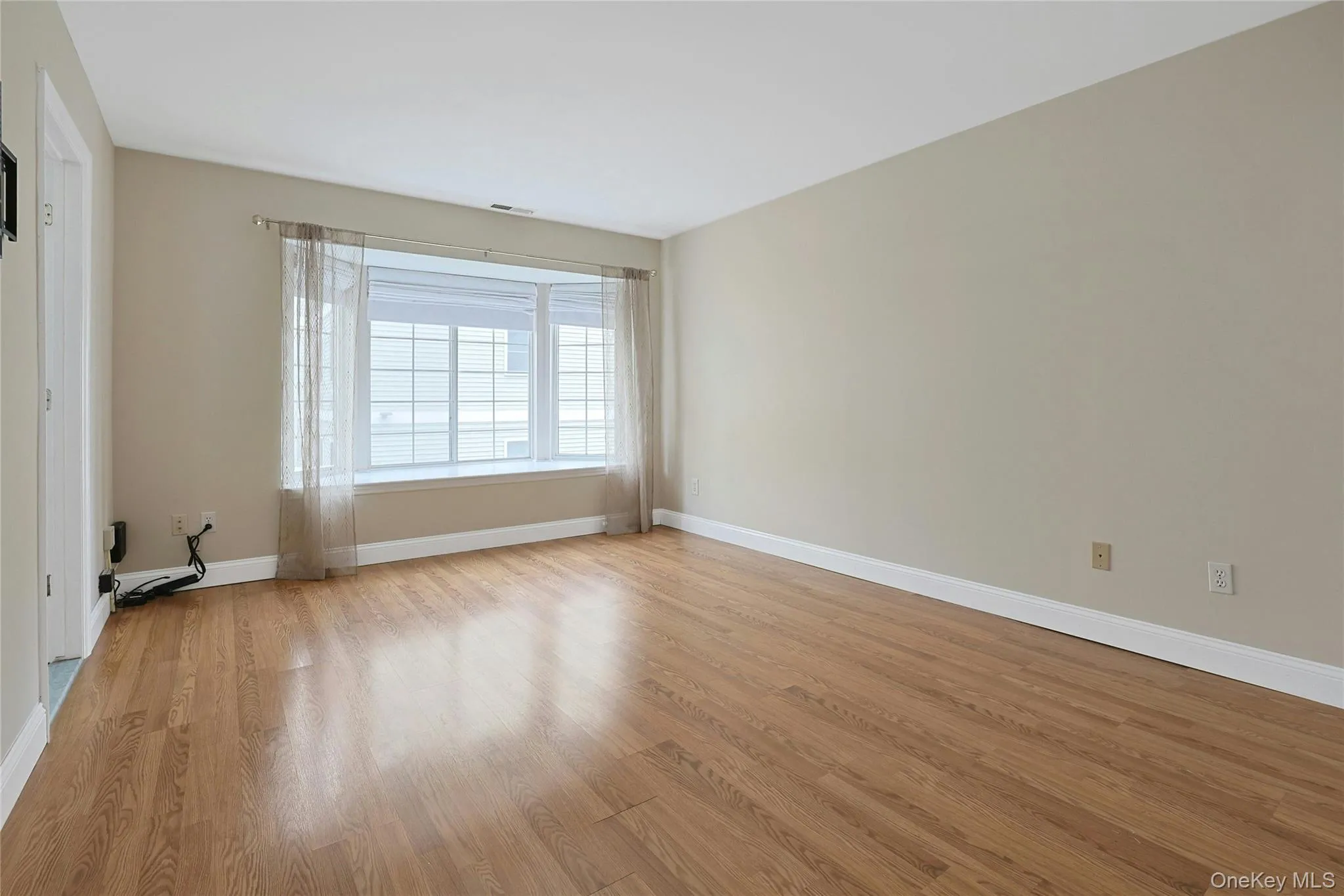 Oversized bedroom with large bay window including elegant shades and window treatments. Oversized bedroom with large bay window including elegant shades and window treatments.