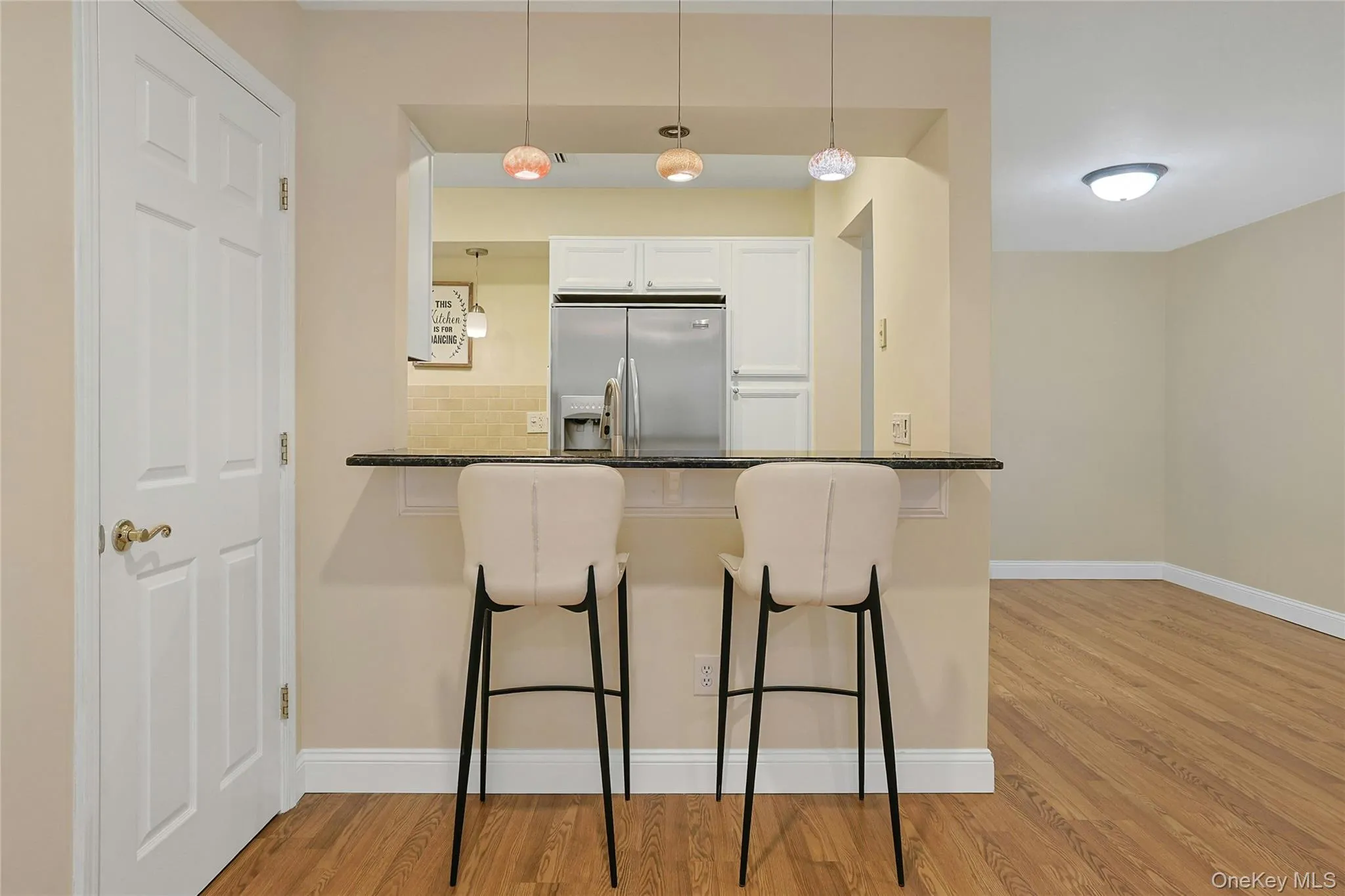Features breakfast bar with pendant lighting and pass through into updated and modern kitchen. Large coat/storage closet on left. Features breakfast bar with pendant lighting and pass through into updated and modern kitchen. Large coat/storage closet on left.