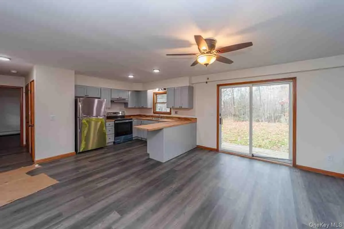 Kitchen with gray cabinets, freestanding refrigerator, range with electric cooktop, dark wood finished floors, and recessed lighting Kitchen with gray cabinets, freestanding refrigerator, range with electric cooktop, dark wood finished floors, and recessed lighting