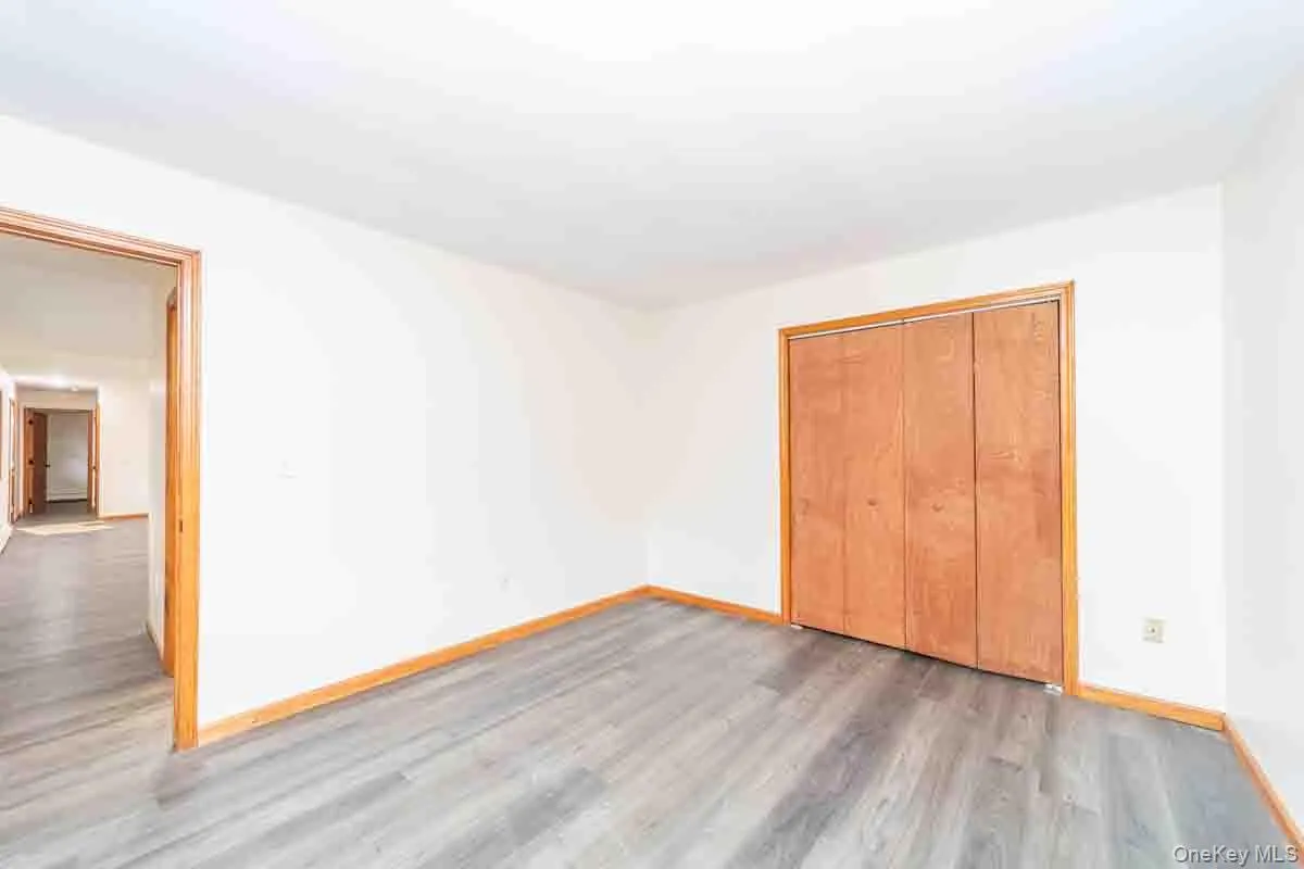 Unfurnished bedroom featuring wood finished floors and a closet Unfurnished bedroom featuring wood finished floors and a closet