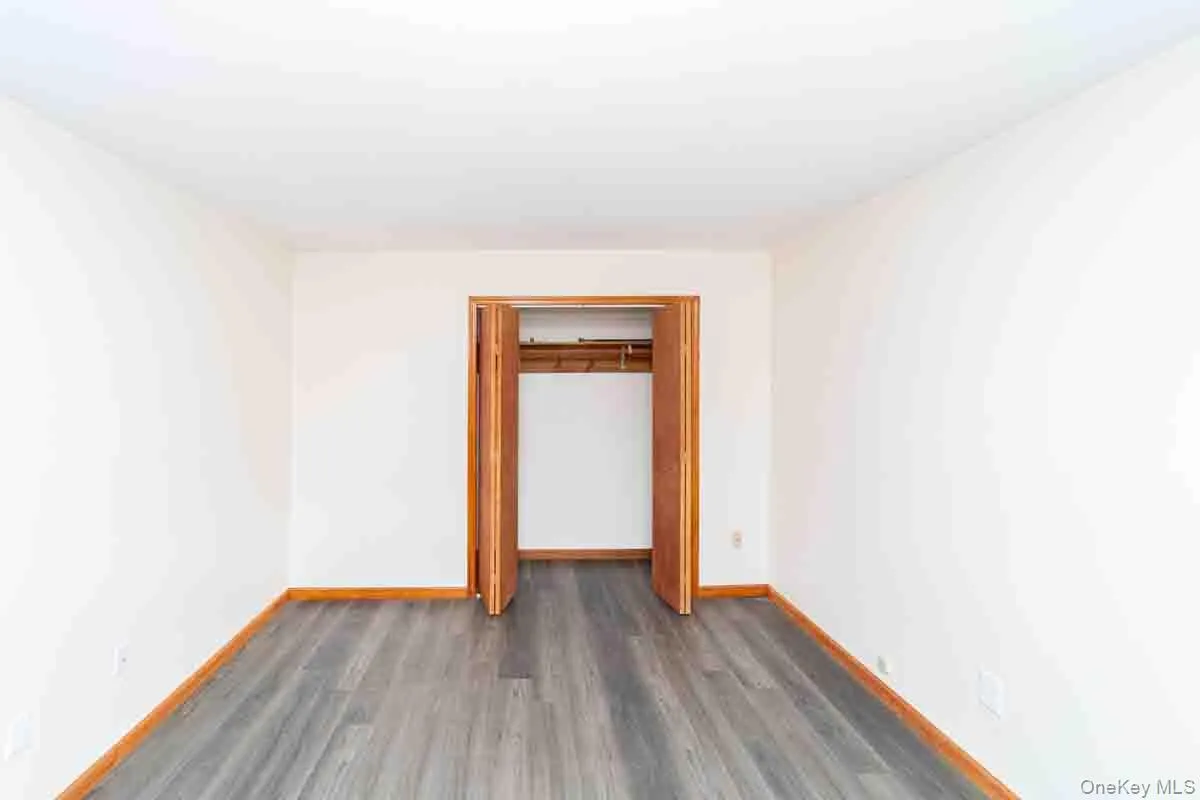 Unfurnished room with dark wood-type flooring and baseboards Unfurnished room with dark wood-type flooring and baseboards