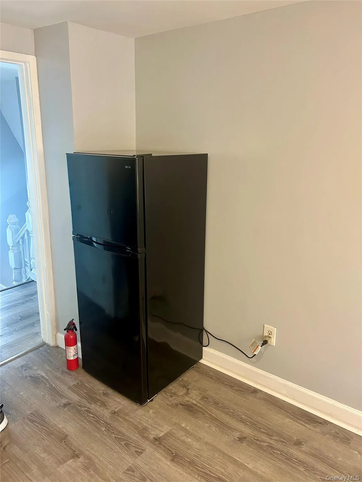 Kitchen view of freestanding refrigerator and light wood-style flooring Kitchen view of freestanding refrigerator and light wood-style flooring