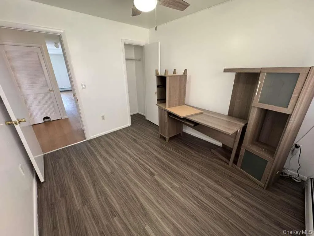 Unfurnished bedroom with dark wood finished floors, ceiling fan, and a closet Unfurnished bedroom with dark wood finished floors, ceiling fan, and a closet