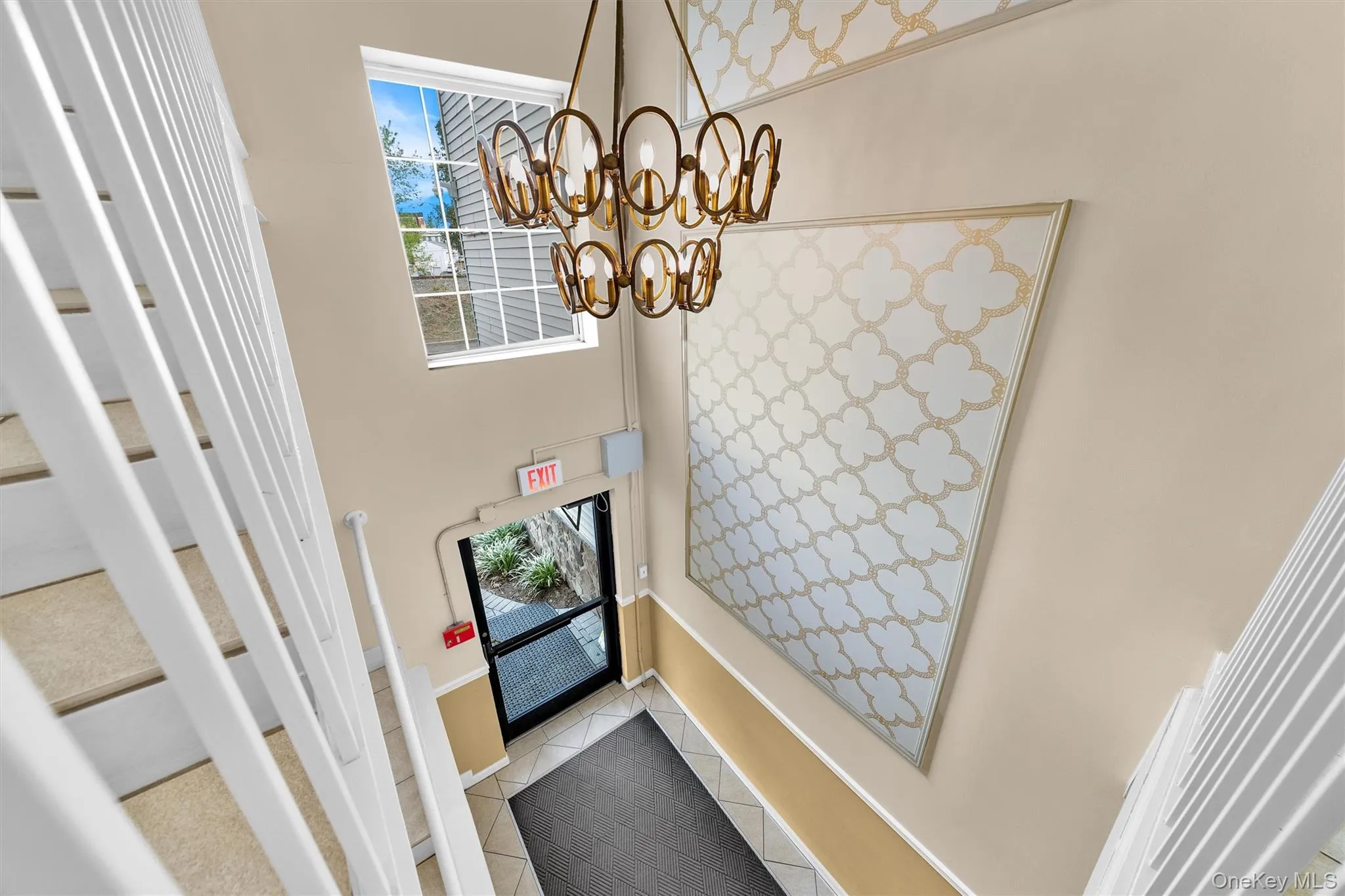 Tiled foyer entrance with an inviting chandelier and stairway Tiled foyer entrance with an inviting chandelier and stairway