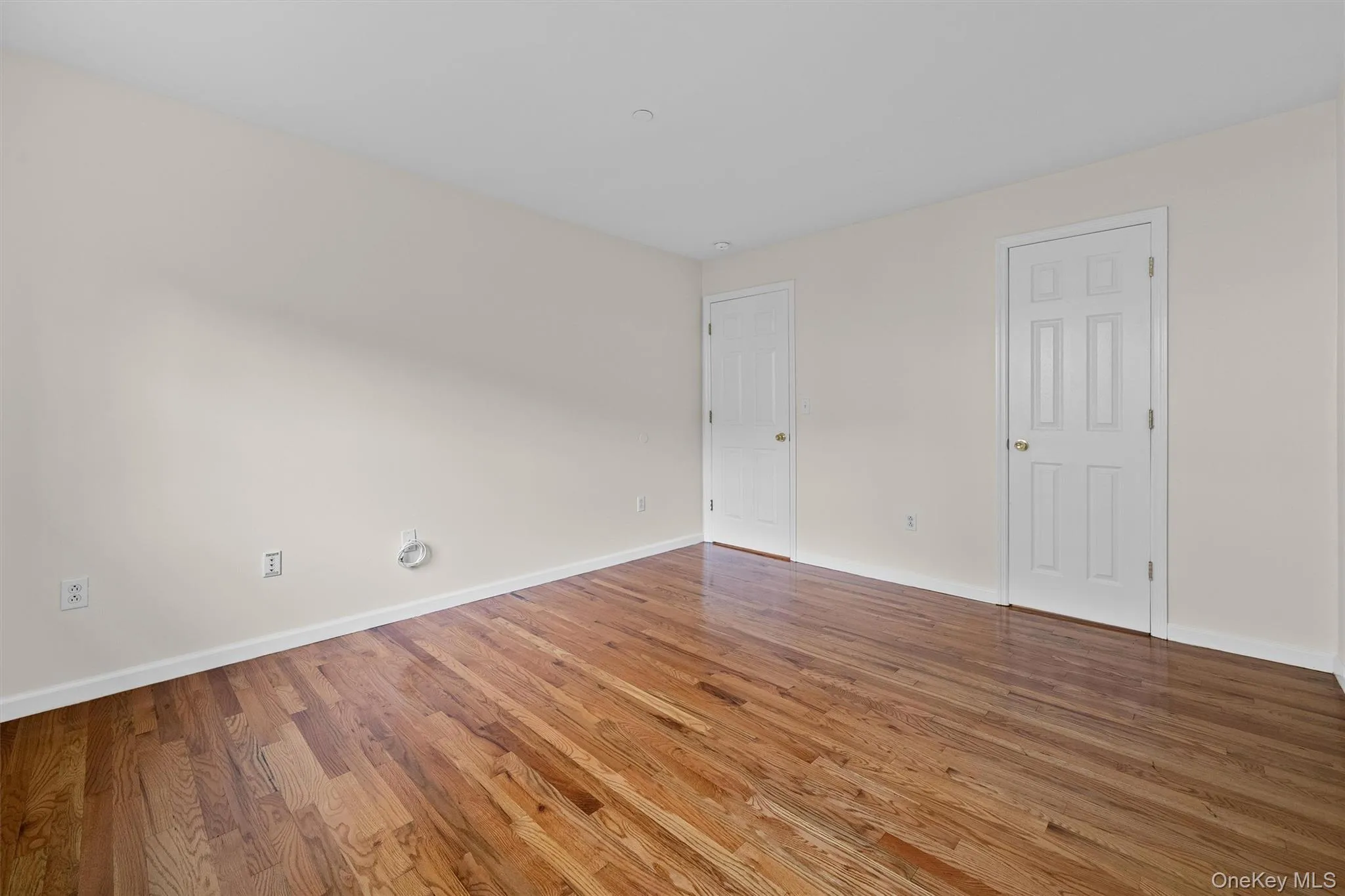 Unfurnished room with wood finished floors and baseboards Unfurnished room with wood finished floors and baseboards