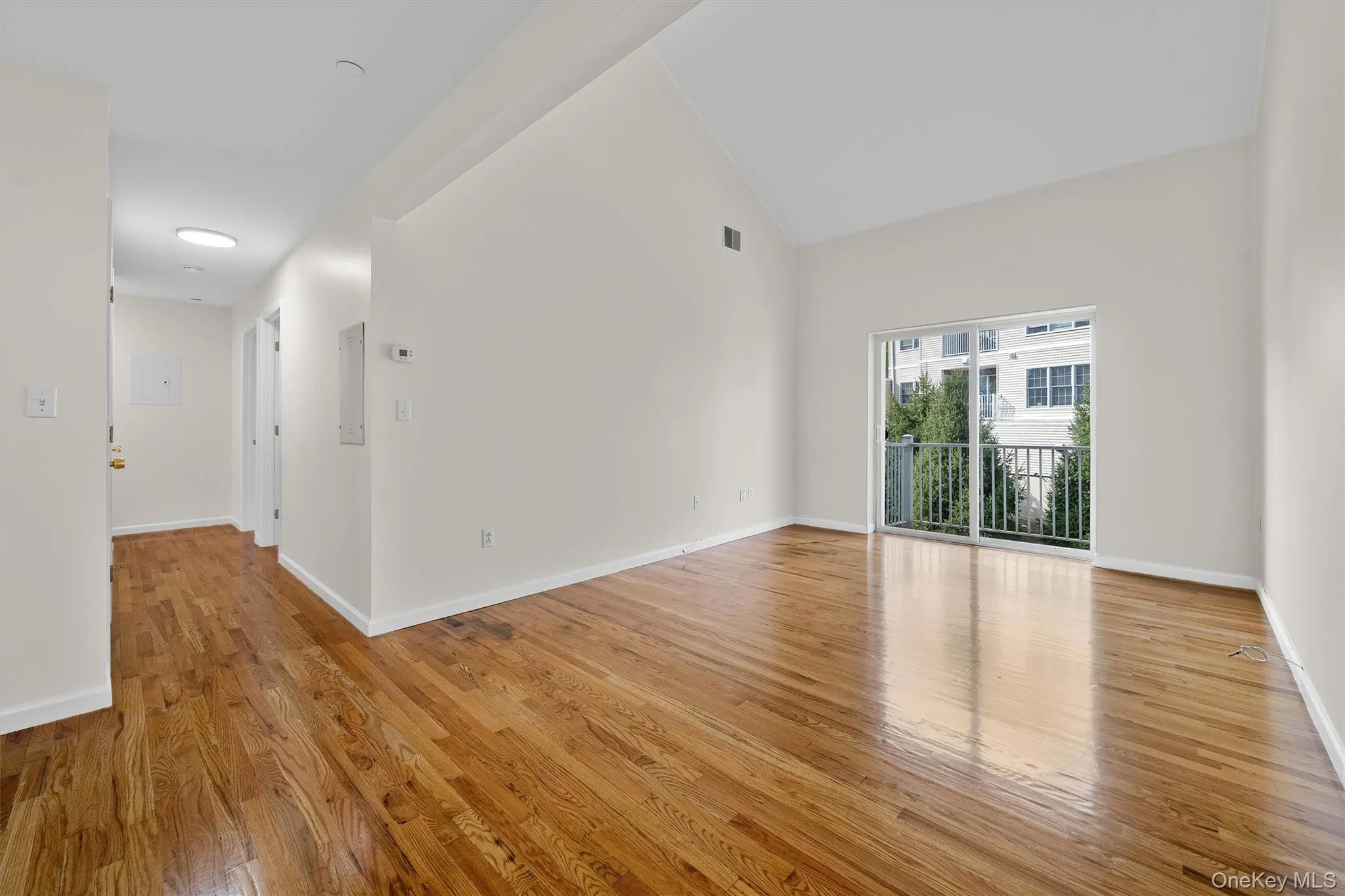 Unfurnished room featuring baseboards, light wood-type flooring, visible vents, and high vaulted ceiling Unfurnished room featuring baseboards, light wood-type flooring, visible vents, and high vaulted ceiling