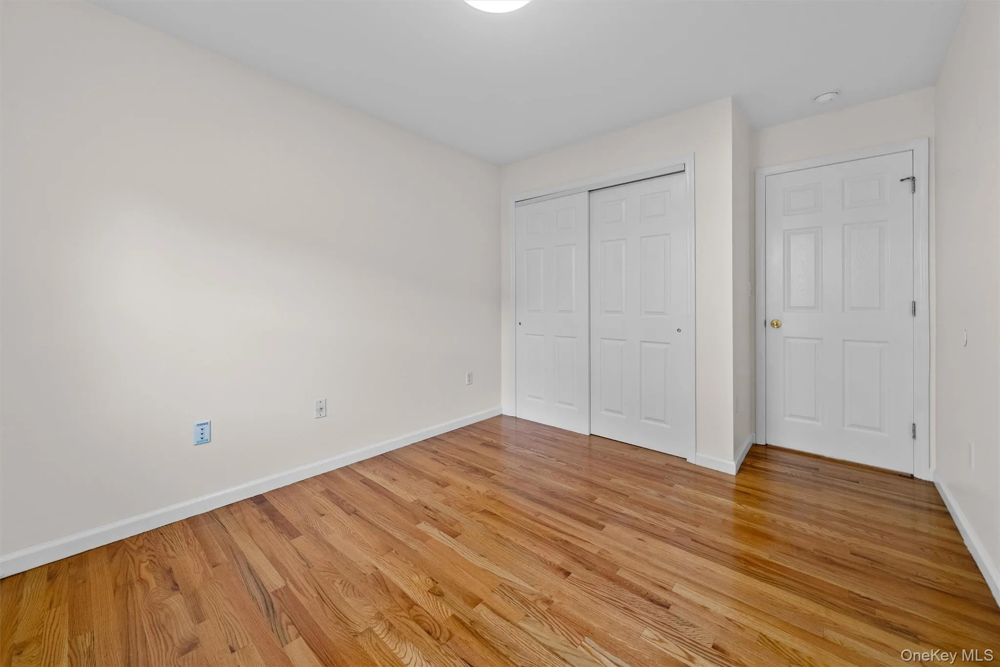 Unfurnished bedroom featuring baseboards, a closet, and light wood-style flooring Unfurnished bedroom featuring baseboards, a closet, and light wood-style flooring