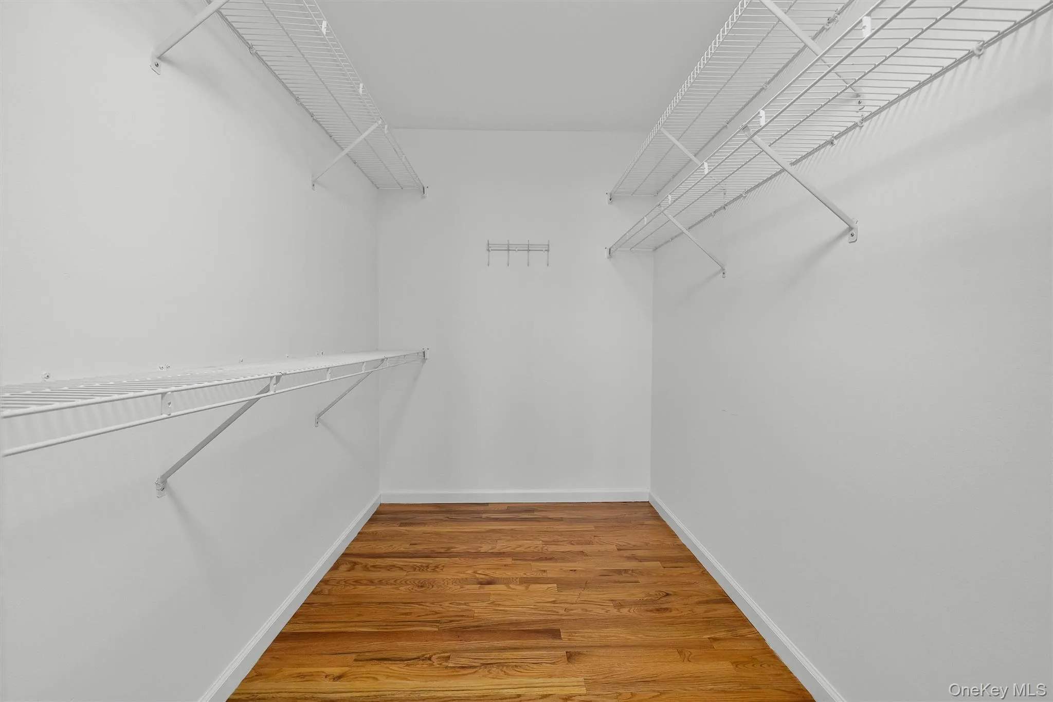 Walk in closet with light wood-style floors Walk in closet with light wood-style floors