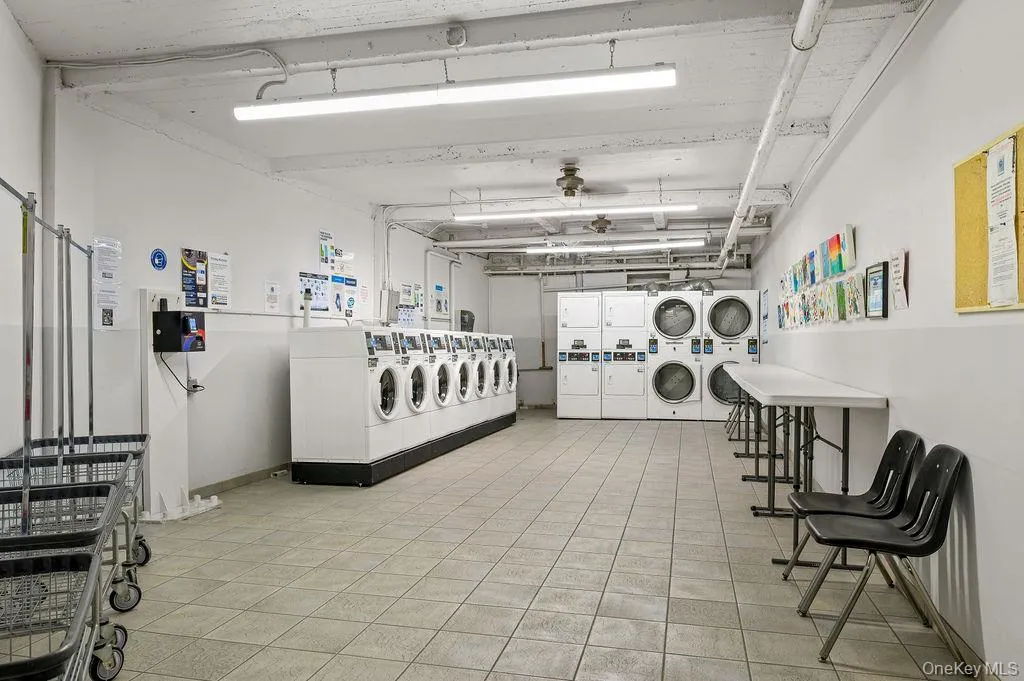 Shared laundry room featuring stacked washer / drying machine and independent washer and dryer Shared laundry room featuring stacked washer / drying machine and independent washer and dryer