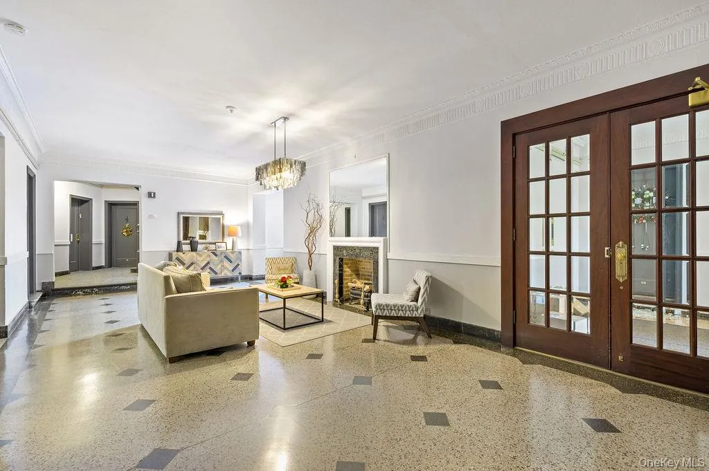 Living area with french doors, a fireplace, crown molding, and a chandelier Living area with french doors, a fireplace, crown molding, and a chandelier