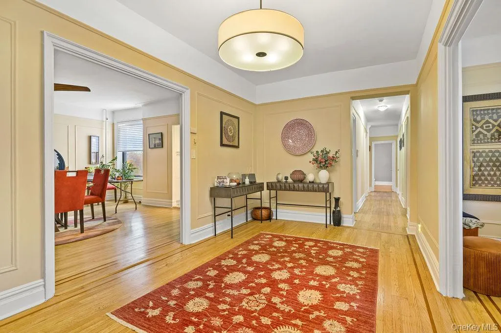 Corridor featuring light wood-style floors and a decorative wall Corridor featuring light wood-style floors and a decorative wall