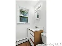 Bathroom featuring vanity and dark wood-style flooring Bathroom featuring vanity and dark wood-style flooring