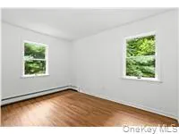 Spare room featuring wood finished floors and baseboards Spare room featuring wood finished floors and baseboards