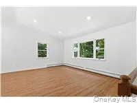 Empty room featuring vaulted ceiling, wood finished floors, healthy amount of natural light, and recessed lighting Empty room featuring vaulted ceiling, wood finished floors, healthy amount of natural light, and recessed lighting