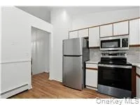 Kitchen with appliances with stainless steel finishes, light countertops, light wood-type flooring, and white cabinetry Kitchen with appliances with stainless steel finishes, light countertops, light wood-type flooring, and white cabinetry