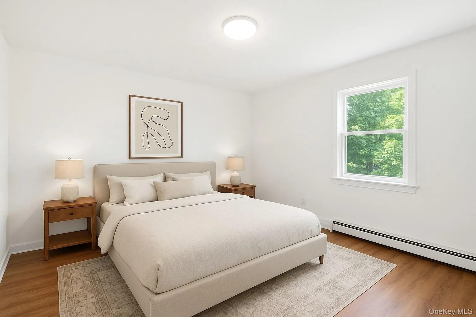 Bedroom with wood finished floors and baseboard heating Bedroom with wood finished floors and baseboard heating