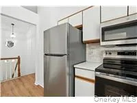 Kitchen featuring stainless steel appliances, light countertops, light wood finished floors, and backsplash Kitchen featuring stainless steel appliances, light countertops, light wood finished floors, and backsplash