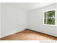Unfurnished room featuring light wood-type flooring and a baseboard heating unit Unfurnished room featuring light wood-type flooring and a baseboard heating unit