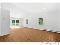 Empty room featuring lofted ceiling and dark wood-style flooring Empty room featuring lofted ceiling and dark wood-style flooring