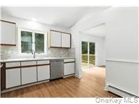 Kitchen with dishwasher, light wood-type flooring, tasteful backsplash, light countertops, and brown cabinets Kitchen with dishwasher, light wood-type flooring, tasteful backsplash, light countertops, and brown cabinets