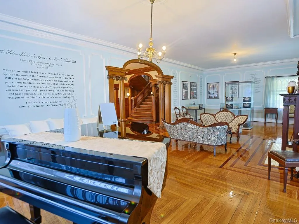 Bedroom with crown molding, a chandelier, and a decorative wall Bedroom with crown molding, a chandelier, and a decorative wall