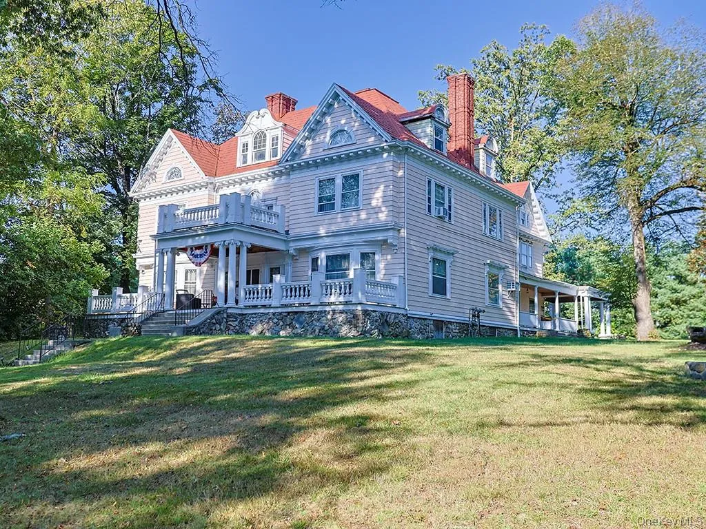 Back of house with a chimney, a yard, and a porch Back of house with a chimney, a yard, and a porch
